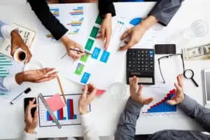 Picture of businessmen's hands on white table with documents and drafts