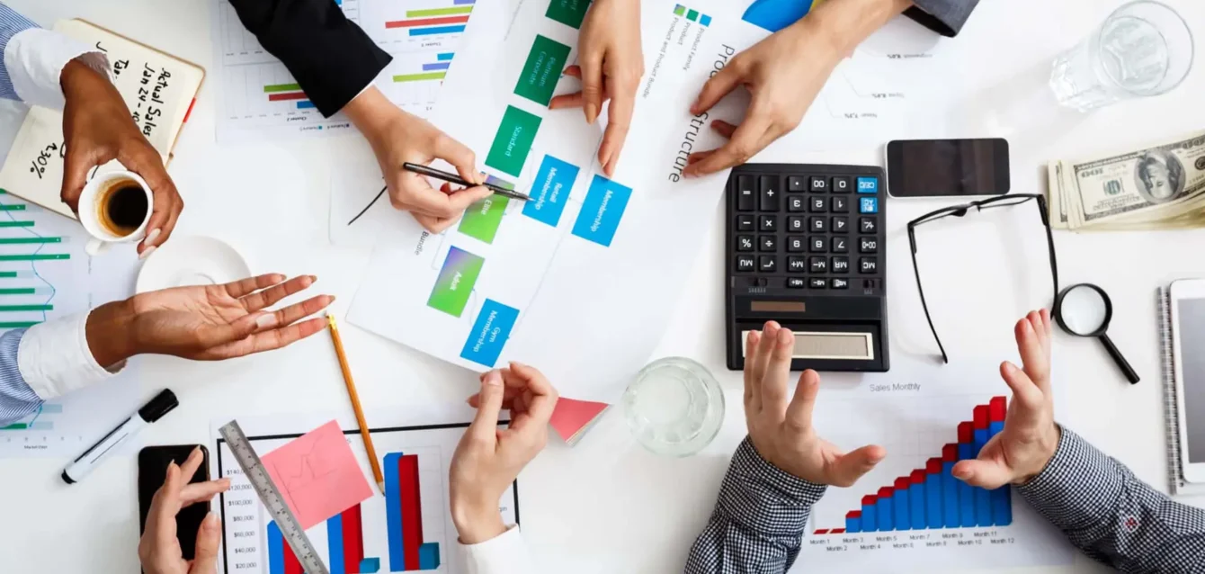 Picture of businessmen's hands on white table with documents and drafts