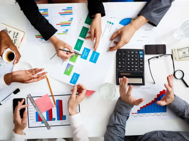 Picture of businessmen's hands on white table with documents and drafts
